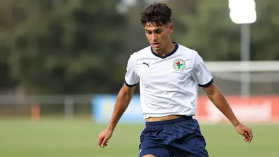A tight action crop of a 26-year-old anonymous player in a Shamrock Rovers jersey, with a clean white shirt and navy blue...