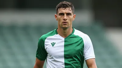 Mid-30s muscular Shamrock Rovers midfielder, intense gaze, dark green and white training shirt, plain cotton weave...